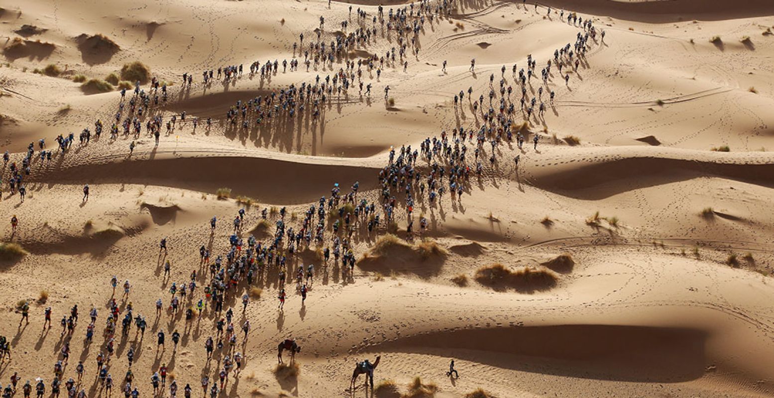Deelnemers starten hun run van 250 km, de 'Marathon des Sables', door de Sahara in het zuiden van Marokko. Ze moeten hun eigen spullen dragen tijdens deze run van zeven dagen. Foto: © Erik Sampers