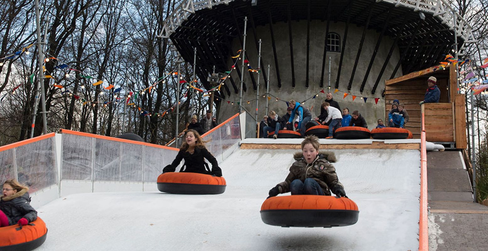 Roetsj van de grote sleebaan naast de molen! Het Nederlands Openluchtmuseum is een winterparadijs voor kinderen. Foto: Nederlands Openluchtmuseum.