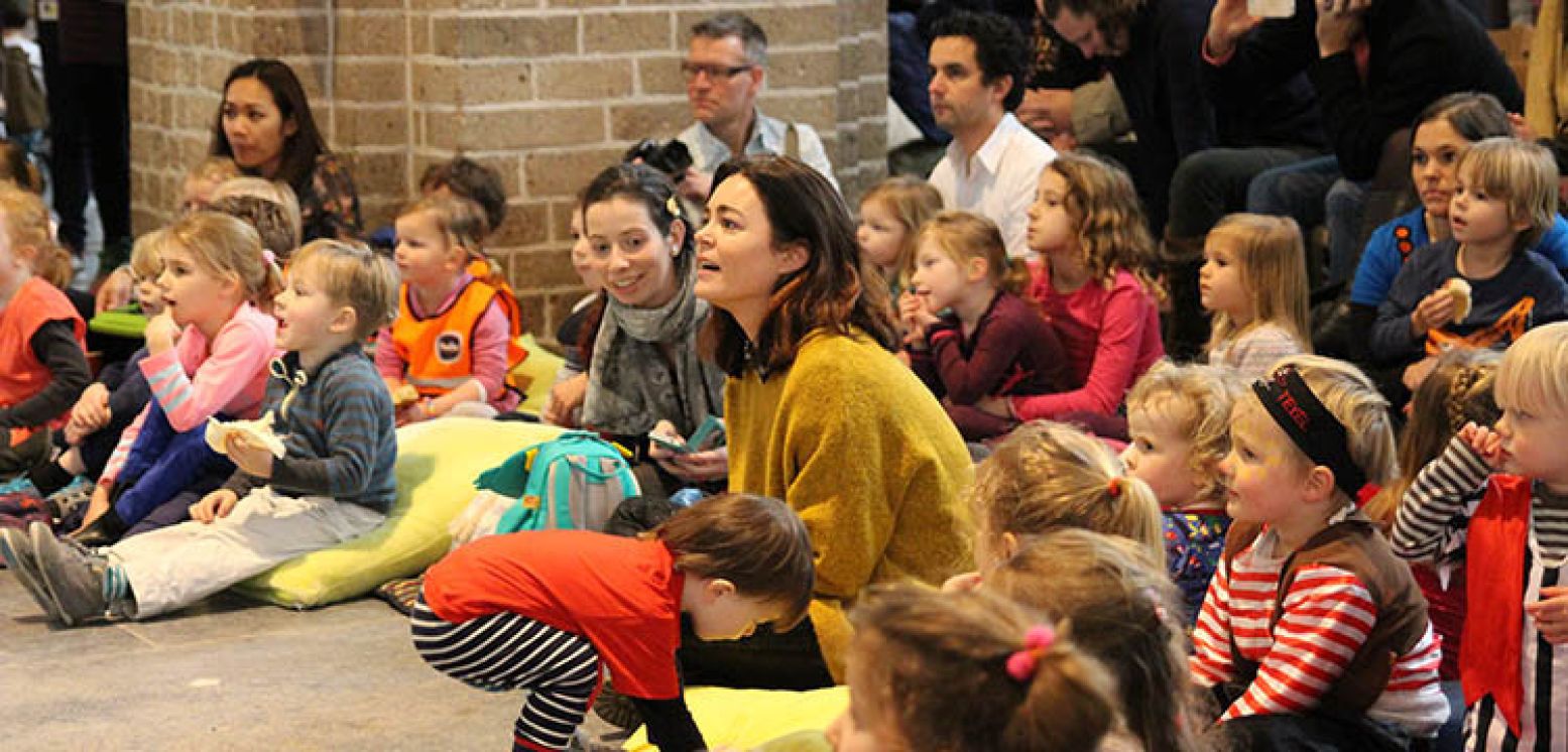 Kim-Lian van der Meij zit tussen de kindjes tijdens de opening in de Nicolaïkerk. Foto: Linda Morren.