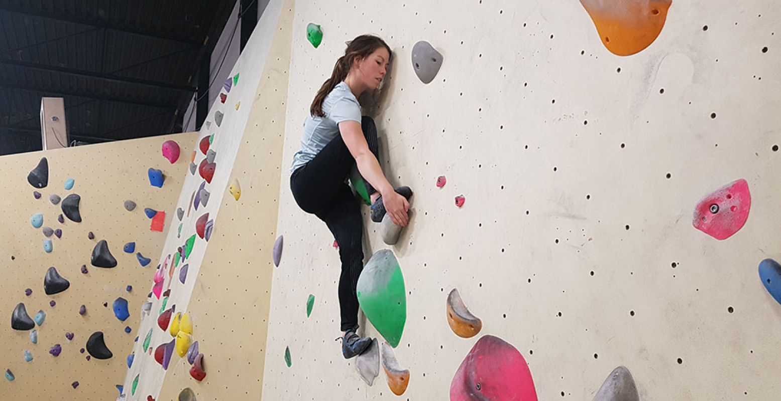 Nikki klimt geconcentreerd omhoog. Boulderen is een sport waarbij je je hele lijf traint. Het is ook een sociale sport en erg leuk om met een groep te doen. Foto: DagjeWeg.NL/Toli