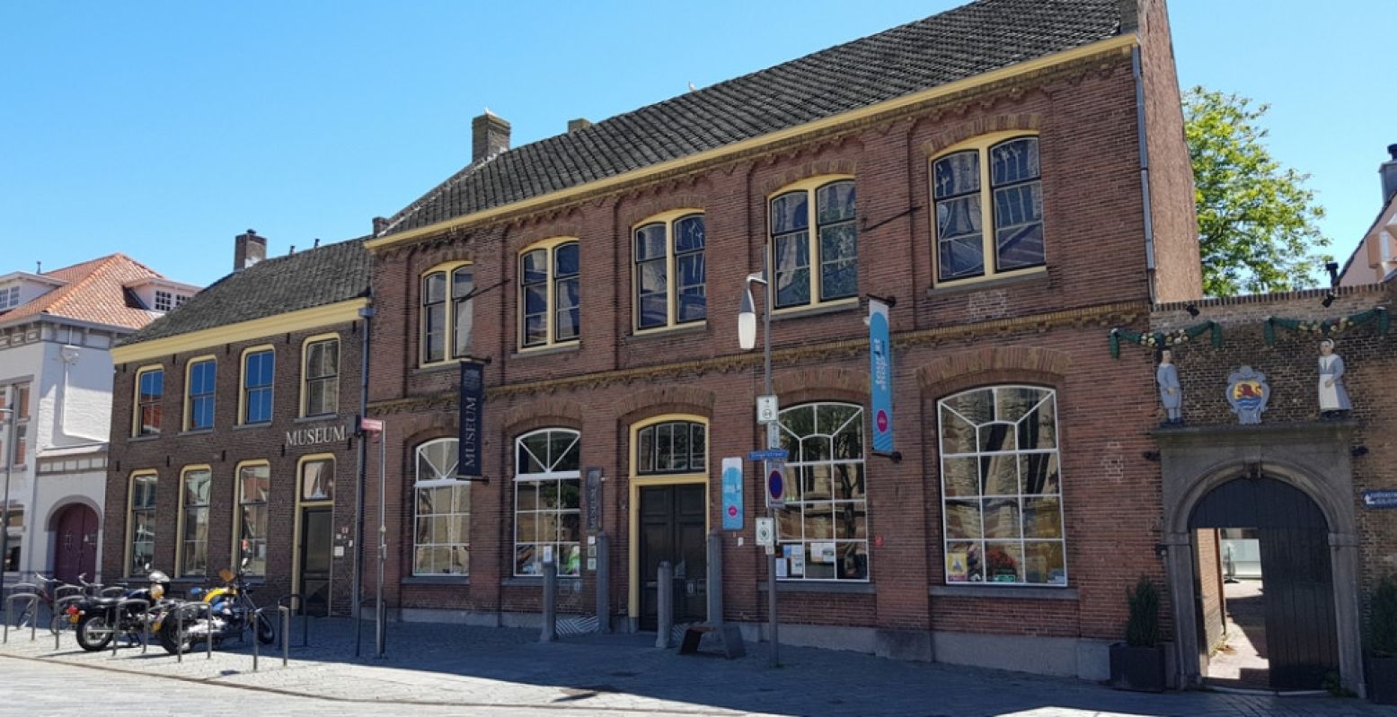 Naast de kerken ligt Historisch Museum de Bevelanden. Rechts één van de twee mooie poorten van het Oude Mannenhuis, nu een hotel. Door dat poortje kom je aan de achterkant waar de tuin van het Mannenhuis ligt. Foto: DagjeWeg.NL @ Tonny van Oosten