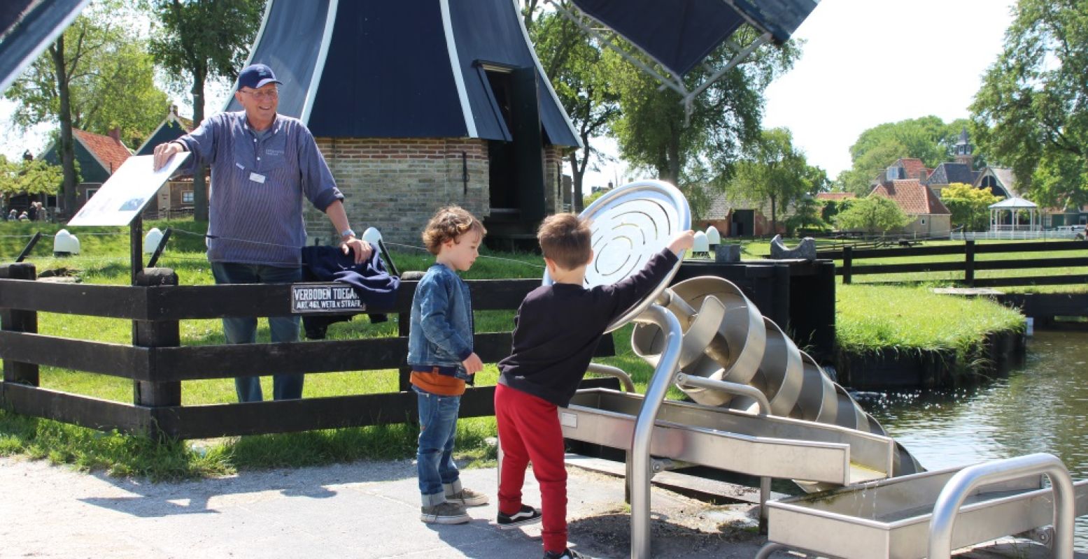 Savi en Mika spelen met het water bij de molen. Foto: DagjeWeg.NL.