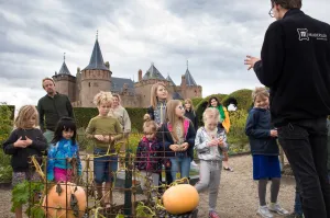 Kinderen luisteren aandachtig naar de uitleg tijdens het Pruimenweekend. Foto: Melanie Lemahieu