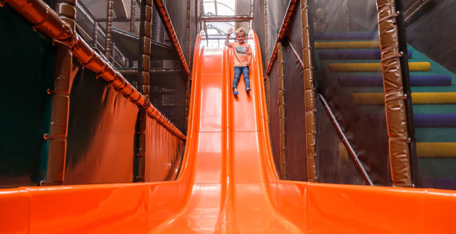 Overdekte speeltuinen Ga van de glijbaan in de binnenspeeltuin van Speelboerderij De Flierefluiter in Raalte. Foto: Speelboerderij De Flierefluiter © Rick Meinen