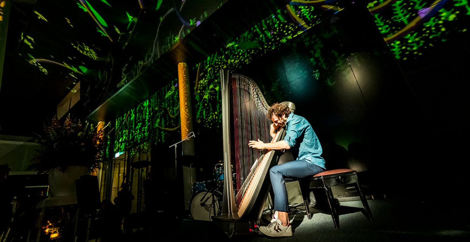 Remy van Kesteren aan het repeteren. Achter hem een voorproefje van de lichtshow op het Museumplein Amsterdam. Credits Van Gogh Museum, foto: Jan-Kees Steenman.