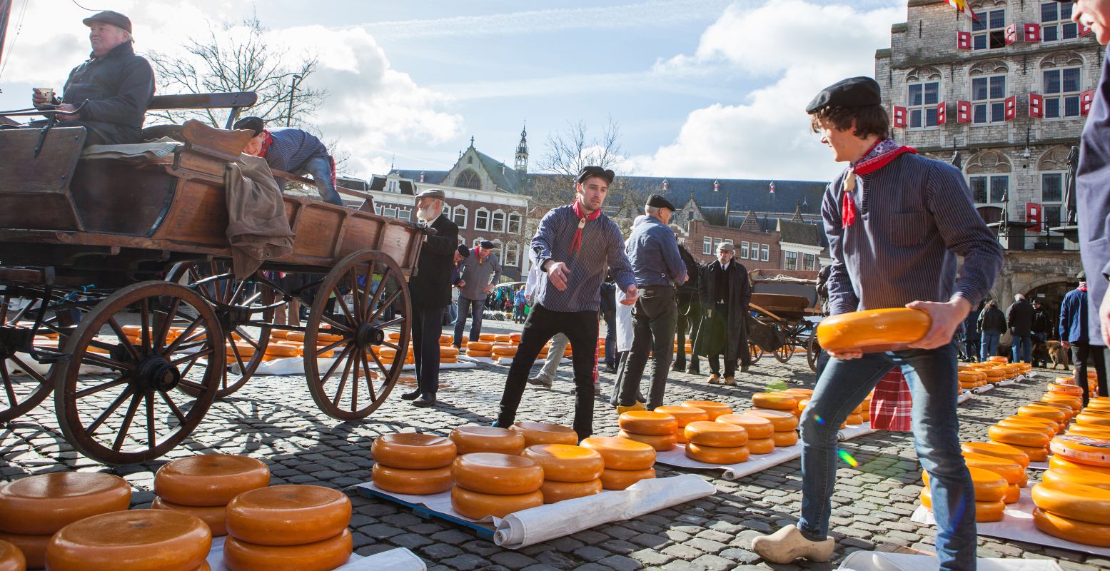 Op de Kaasmarkt voor de Waag gooien handelaren met kazen, een boeiend schouwsspel. Foto: VVV Gouda