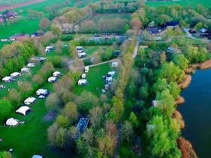 Camping De Watermolen Het groene kampeerterrein bij het meer. Foto: Camping De Watermolen