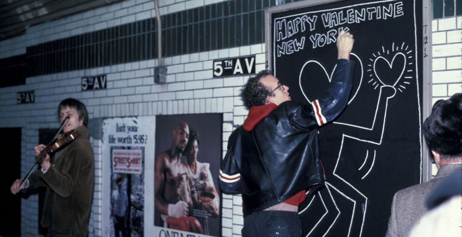 Keith Haring tekent in de metro in New York (1983). Foto: Tseng Kwong Chi © Muna Tseng Dance Projects, Inc. Artwork: © Keith Haring Foundation